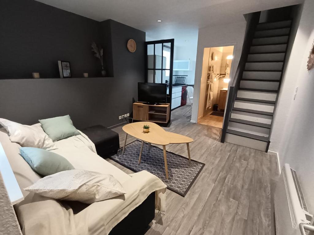 un salon avec un canapé et une table dans l'établissement T2 cosy en duplex, à Libourne