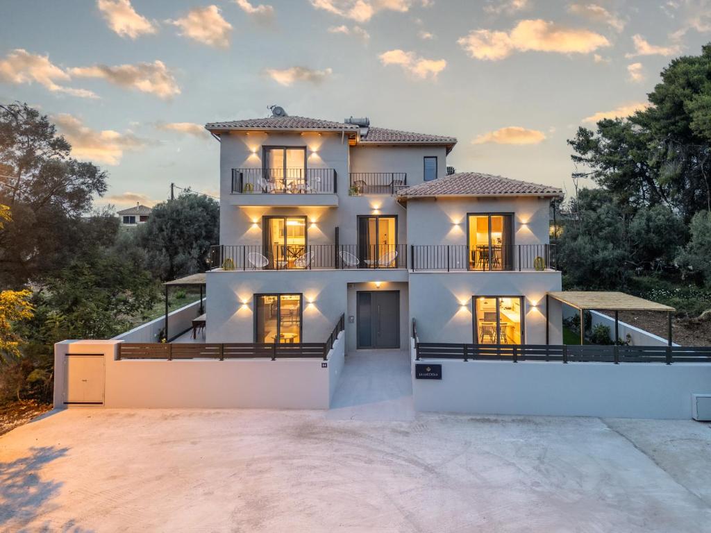 una gran casa blanca con muchas ventanas en La Lucciola apartments, en Lefkada