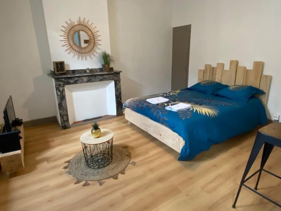 une chambre avec un lit, une table et un miroir dans l'établissement Le B2, parking privé, à Carcassonne