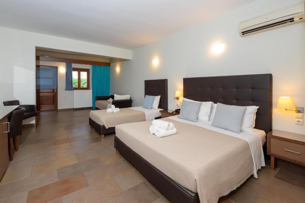 a bedroom with two beds and a living room at Aktaion Resort in Gythio