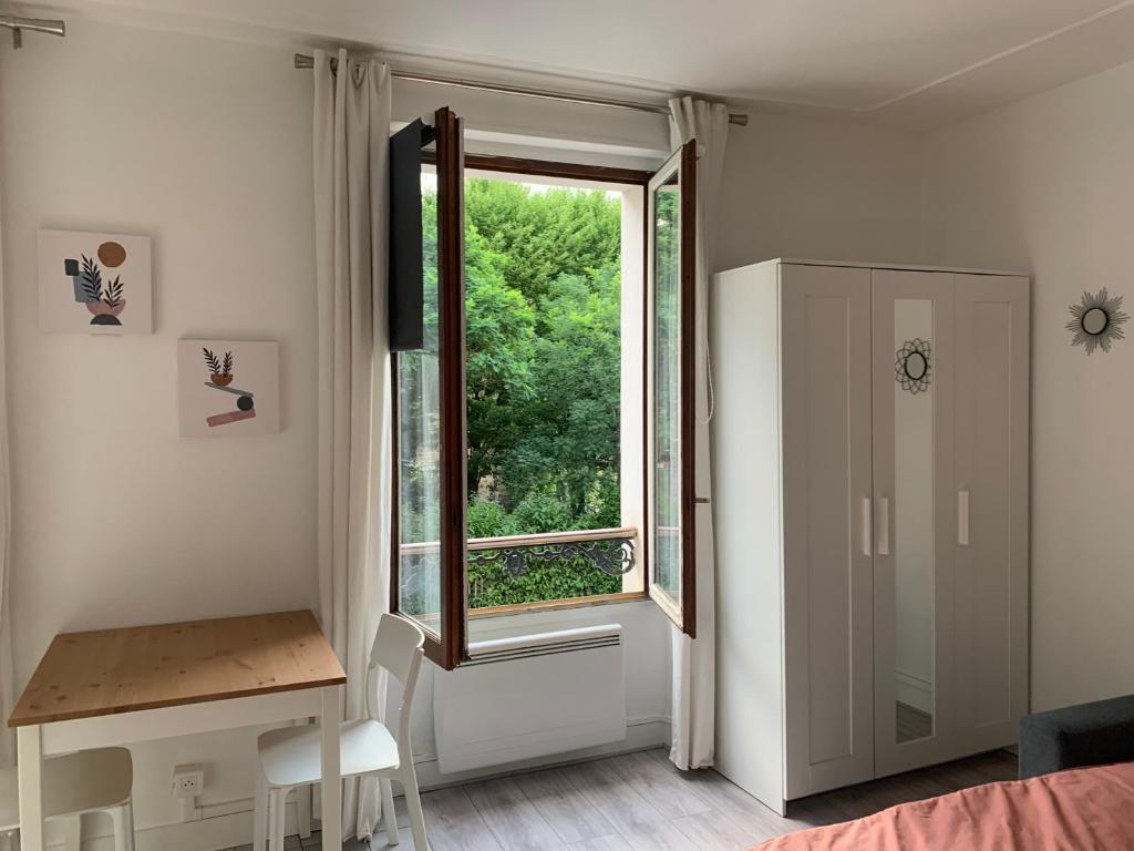 - une chambre avec une fenêtre, un bureau et une table dans l'établissement Studio Gobelins, à Paris