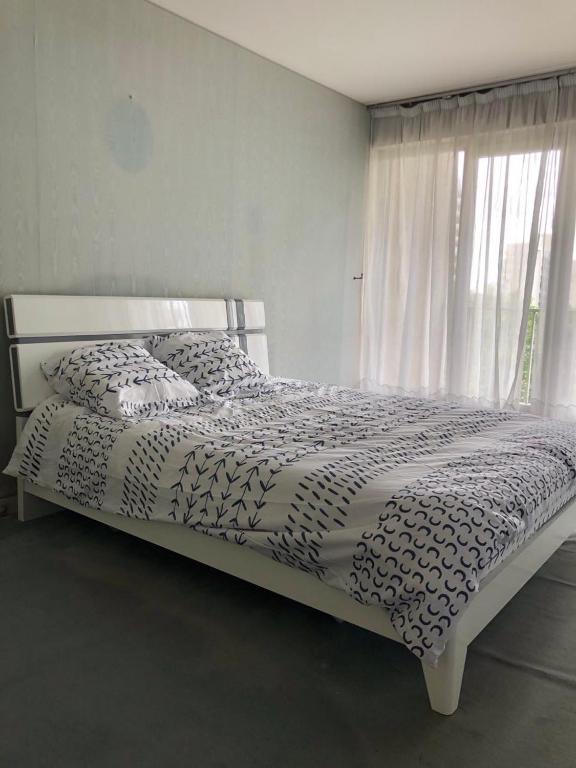 Ce lit se trouve dans un dortoir doté d'une fenêtre et d'un couvre-lit. dans l'établissement Creteil 1, à Créteil