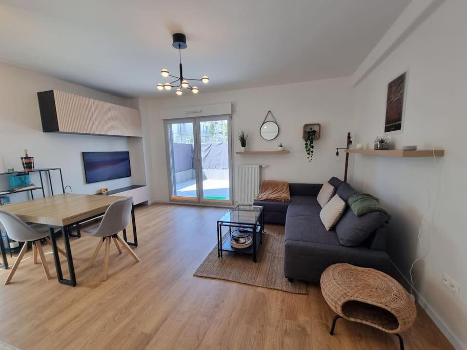 un salon avec un canapé et une table dans l'établissement Cosy retreat with terrasse and parking, near Paris and Disney, 5min to train station, à Champigny-sur-Marne