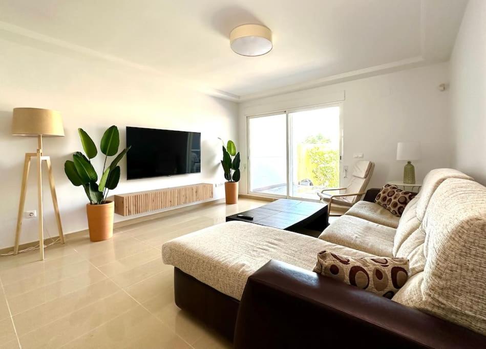 a living room with a couch and a flat screen tv at Vacaciones con el Mediterráneo a menos de 50 metros in Cullera