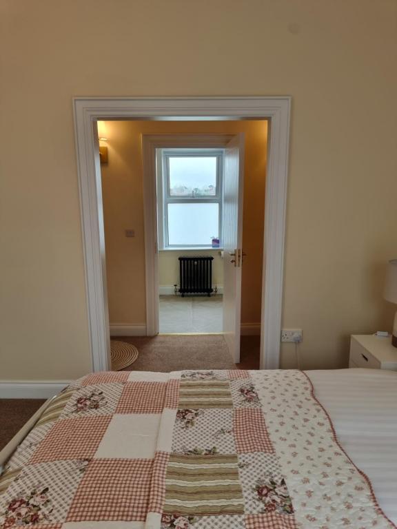 a bedroom with a bed with a quilt on it at Derry Wall's Suite in Derry Londonderry