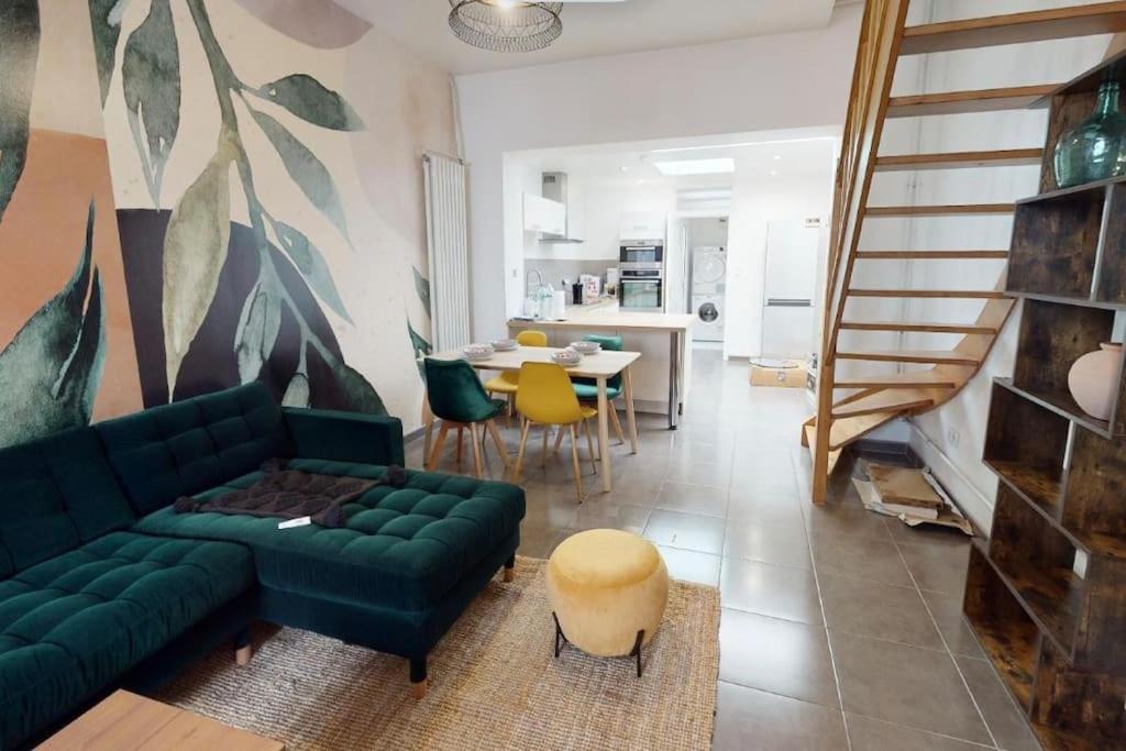 un salon avec un canapé vert et une table dans l'établissement Jungle House, à Roubaix