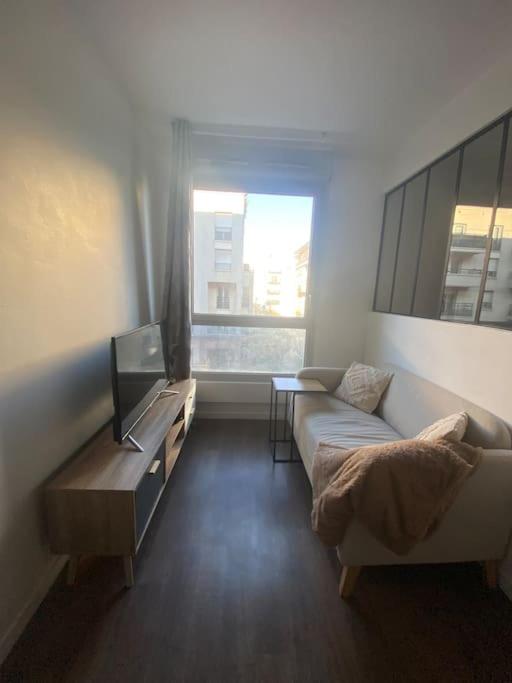 un salon avec un canapé et une télévision dans l'établissement Studio proche Paris, à Rosny-sous-Bois