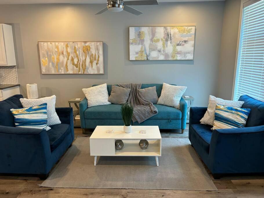 ein Wohnzimmer mit blauen Sofas und einem Couchtisch in der Unterkunft Gated Hideaway in Greenville in Greenville