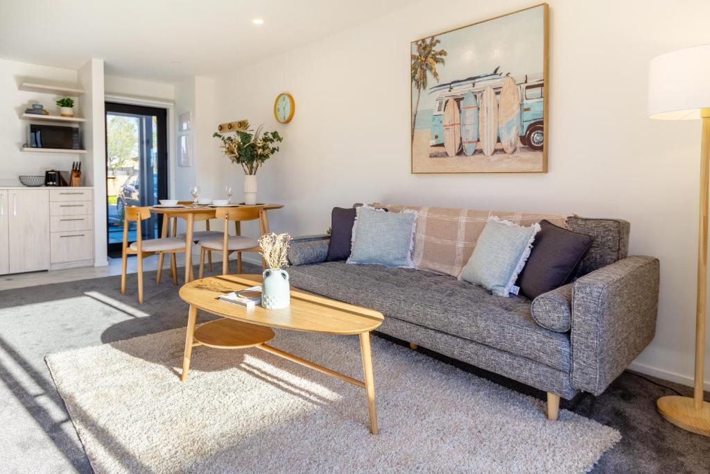 a living room with a couch and a table at Elegant Living by Middleton Park, Fully Equipped in Christchurch