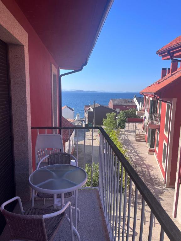 a balcony with a table and chairs and the ocean at Apartamento Estrellas de Mar in Ribeira