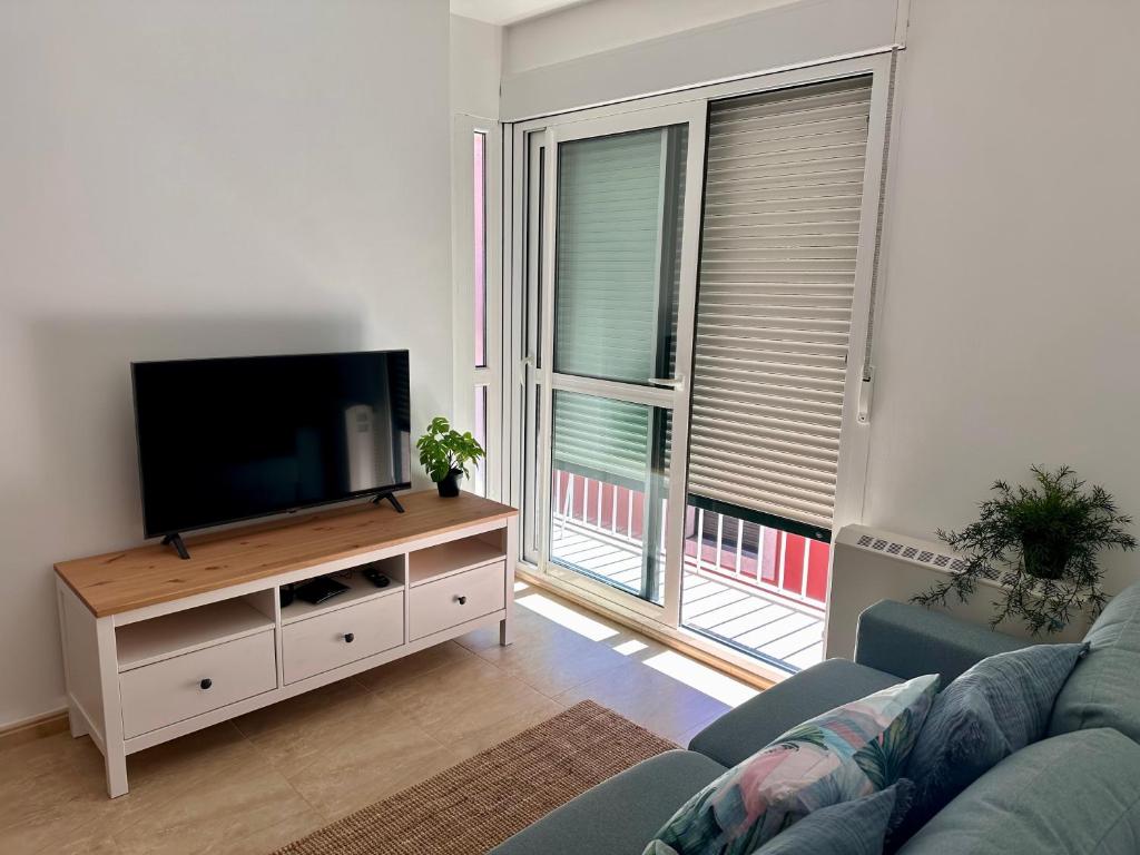 un soggiorno con TV a schermo piatto e divano di Apartamento Estrellas de Mar a Ribeira