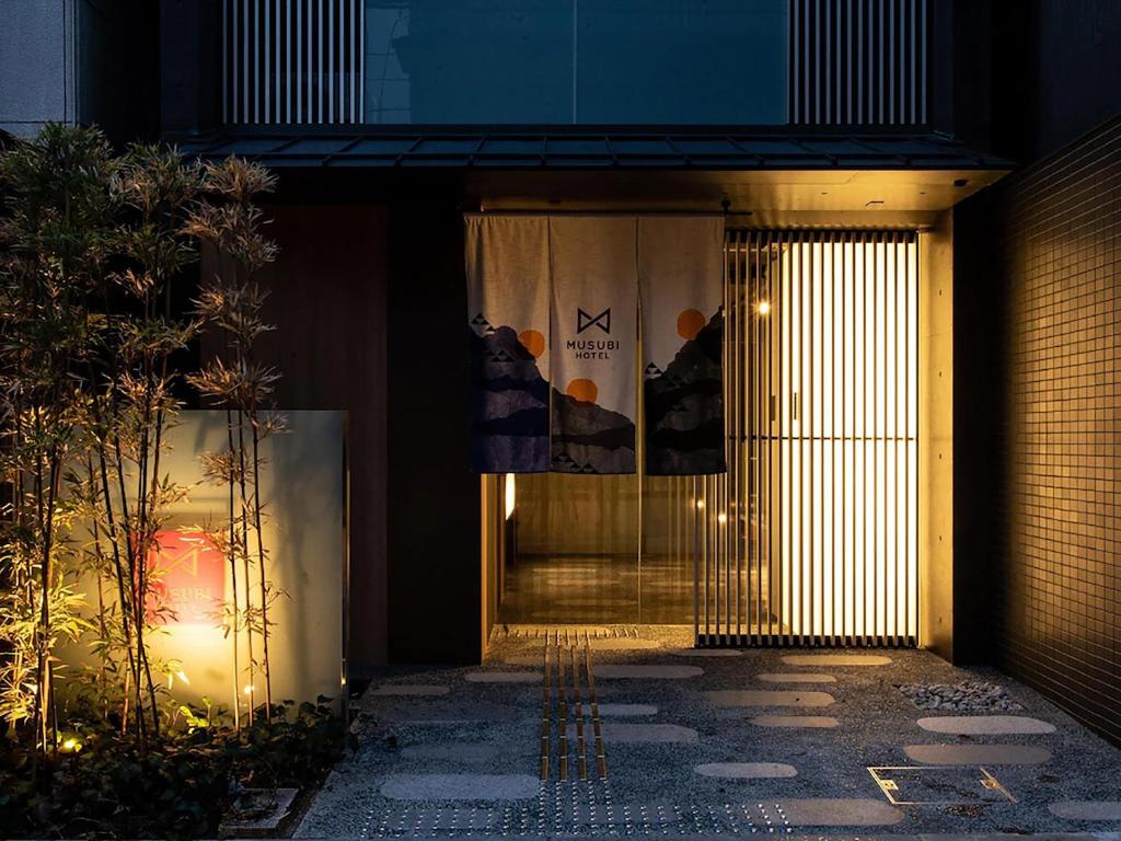 un ingresso di notte a un edificio con luci di MUSUBI HOTEL Kyoto Shijo-Omiya a Kyoto