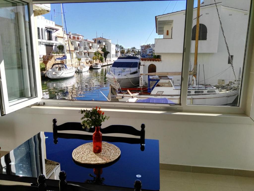 einem Tisch vor einem Fenster mit Booten im Wasser in der Unterkunft Waterside Apartment - Two Bedroom in Empuriabrava
