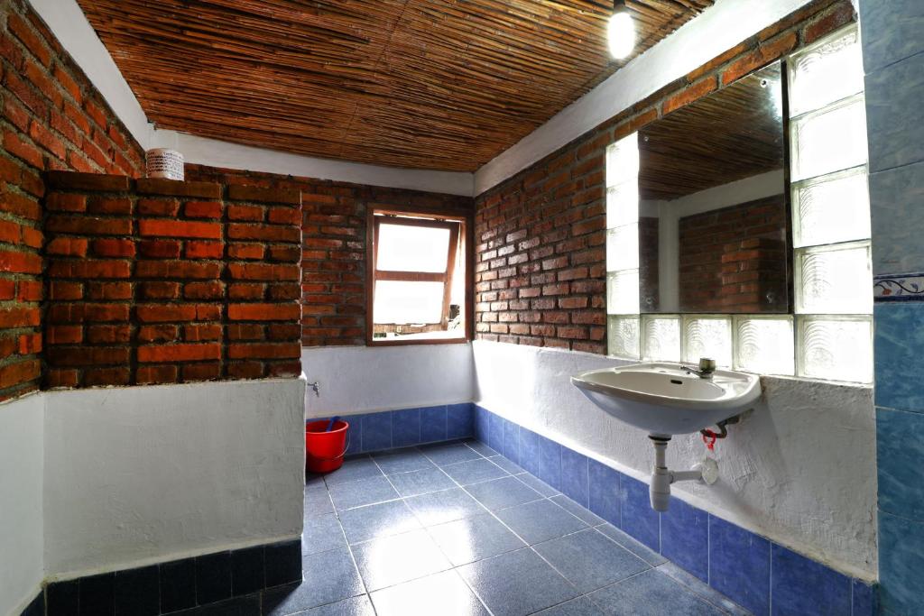 a bathroom with a sink and a brick wall at Bagus Bay Homestay in Tuktuk Siadong
