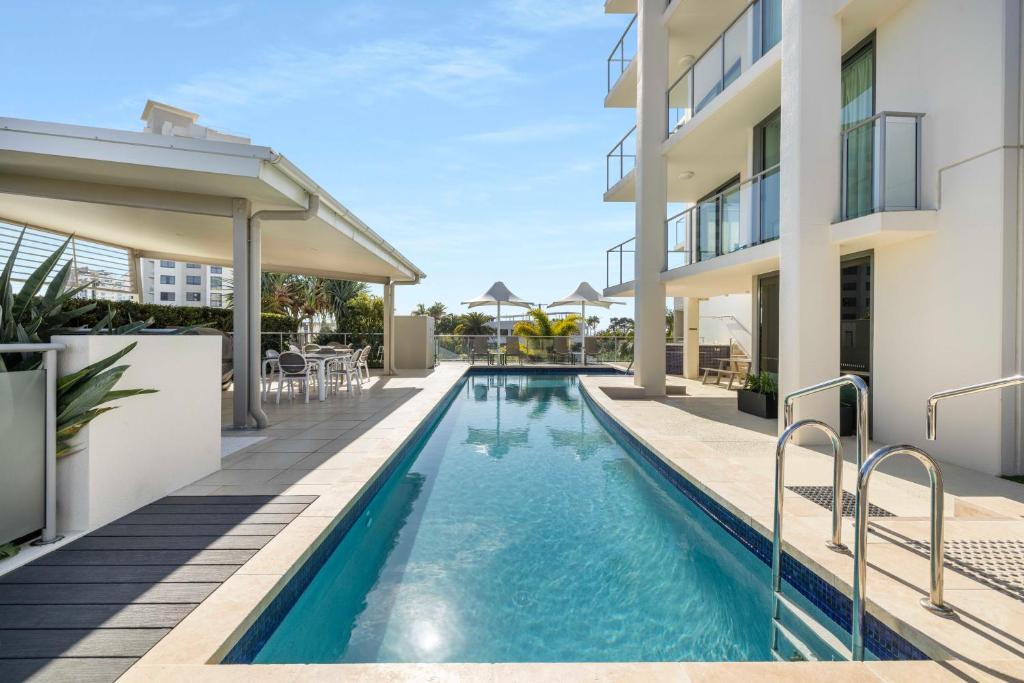 an image of a swimming pool next to a building at Beach on Sixth in Maroochydore