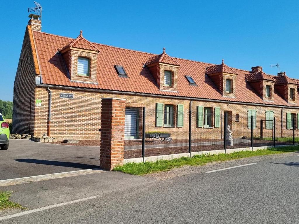 un grand bâtiment en briques avec un toit rouge dans l'établissement Charmante maison mitoyenne avec jardin, proche forêt, animaux admis, parking & WiFi - FR-1-510-203, à Hasnon