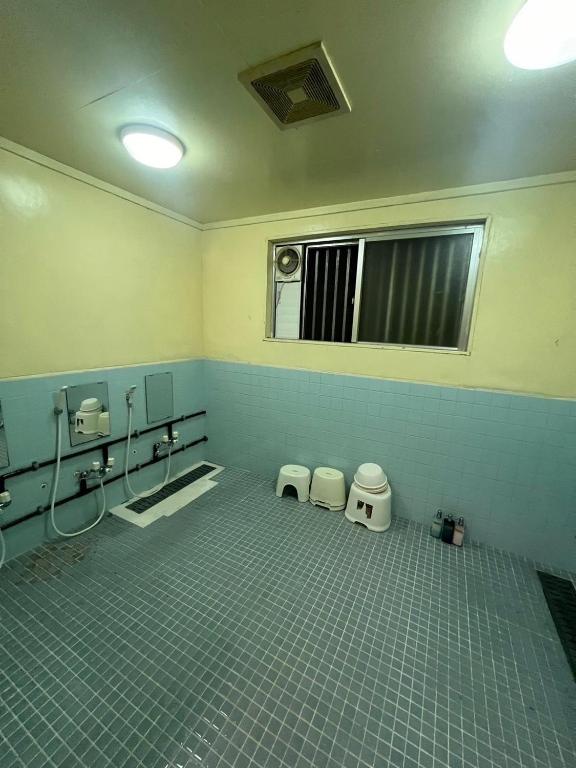 an empty bathroom with two toilets and a window at やどバンブー in Hateruma