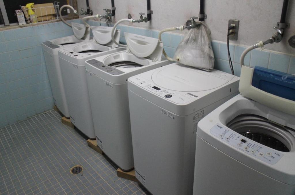 a group of three washing machines in a laundry room at やどバンブー in Hateruma