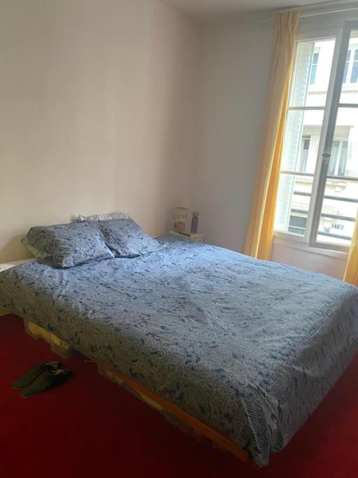 une chambre avec un lit et une fenêtre dans l'établissement Appartement mignon et confortable avec accès jardin, à Paris