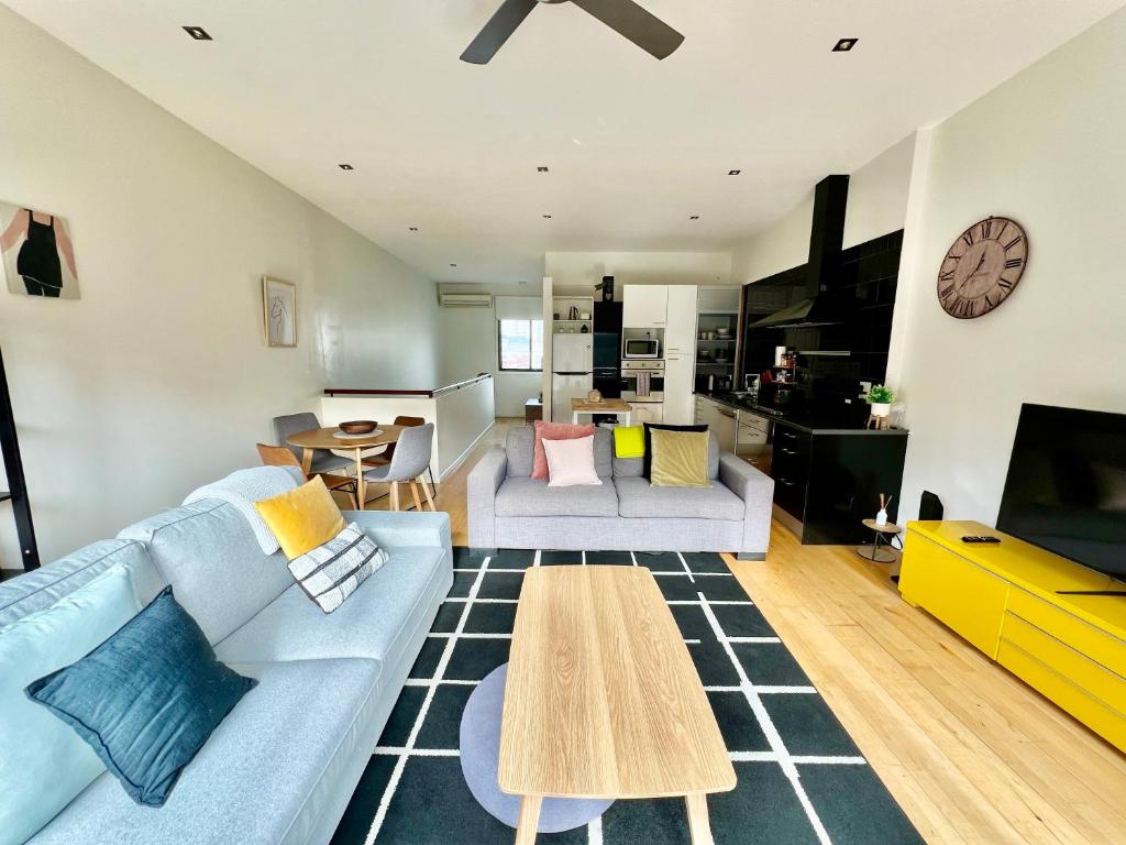 a living room with a blue couch and a table at Ascot Vale - Lovely 2 bedroom townhouse close to everything! in Ascot Vale