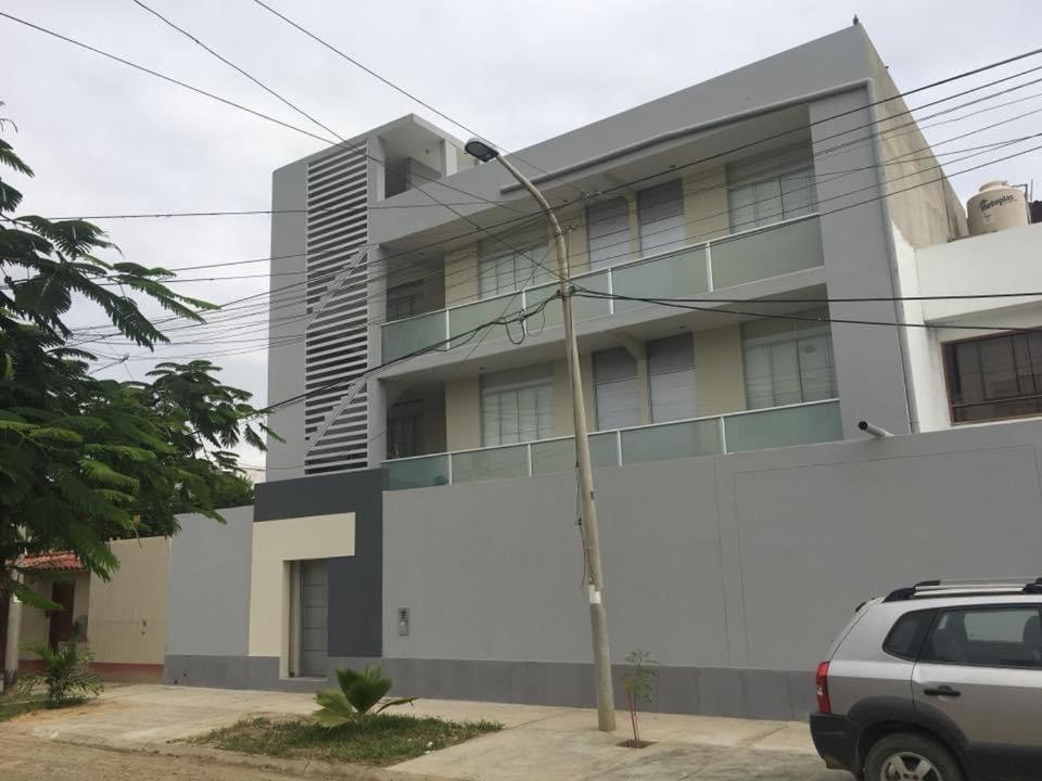 ピウラにあるLos Cocos del Chipe Suitesの建物の前に車が駐車されている