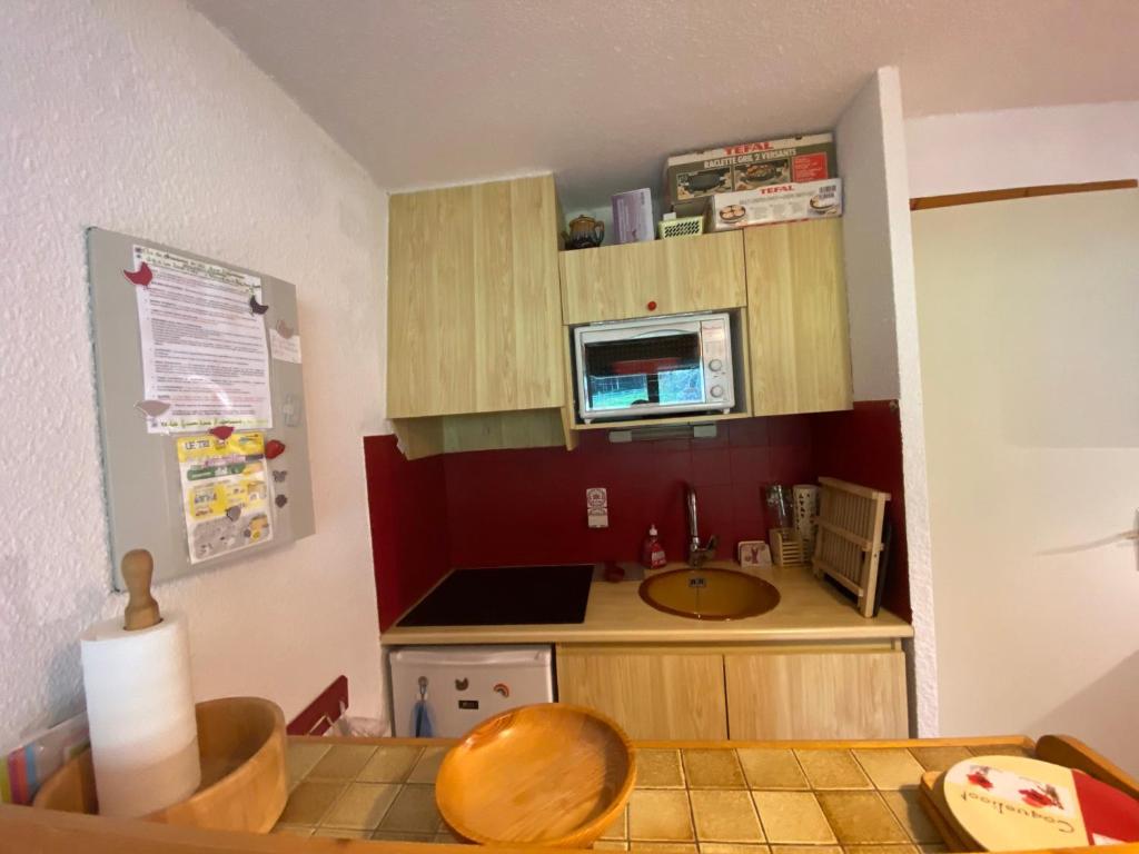 une petite cuisine avec un évier et un micro-ondes dans l'établissement Appartement cosy à Châtel - 4 pers, balcon, parking, proche télécabine, accès WIFI, animaux admis - FR-1-198-265, à Châtel