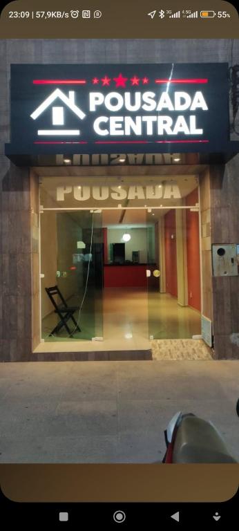 a sign for a pueblo central building with a chair at Pousada central Russana in Russas