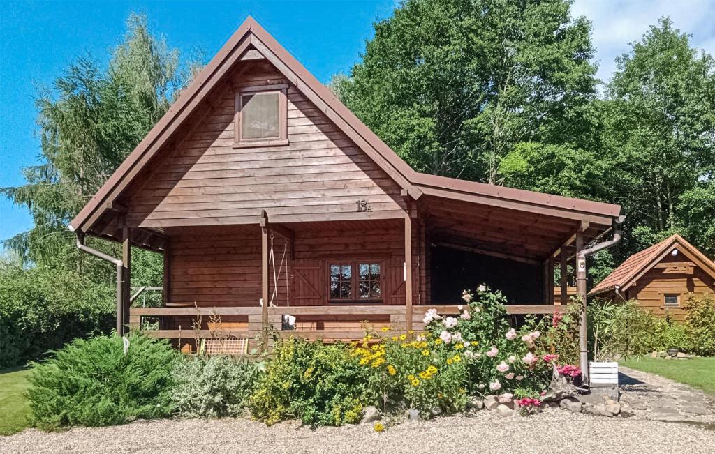 una baita di tronchi con fiori di fronte di Gorgeous Home In Zalewo With Lake View a Boreczno