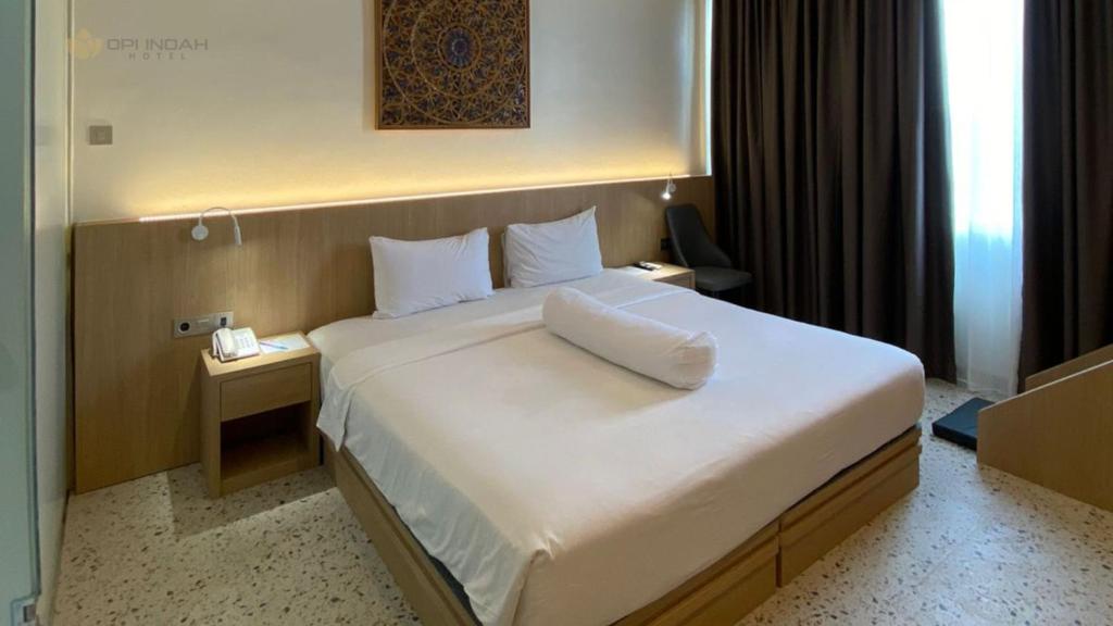 Postel nebo postele na pokoji v ubytování OPI Indah Hotel