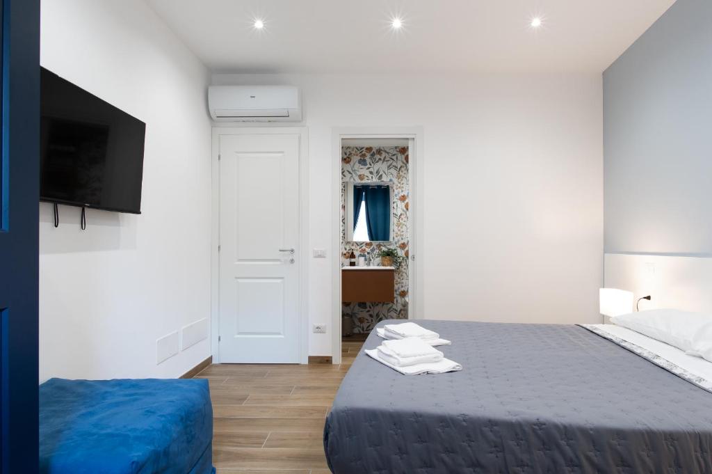 a white bedroom with a bed and a tv at Rhoome Holiday 1 in Rome