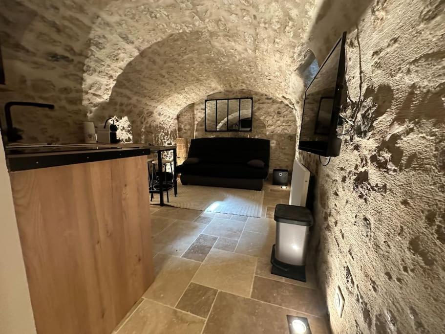 un salon avec un canapé et un mur en pierre dans l'établissement La Cave du Port - CDDT, à La Rochelle