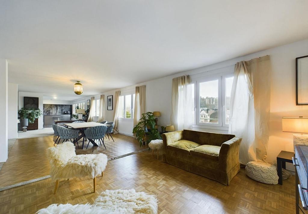 una sala de estar con un sofá y una mesa en Appartement spacieux plein centre, 6 personnes, 3 chambres, 3 Salles de bain, superbe vue Château, en Épinal