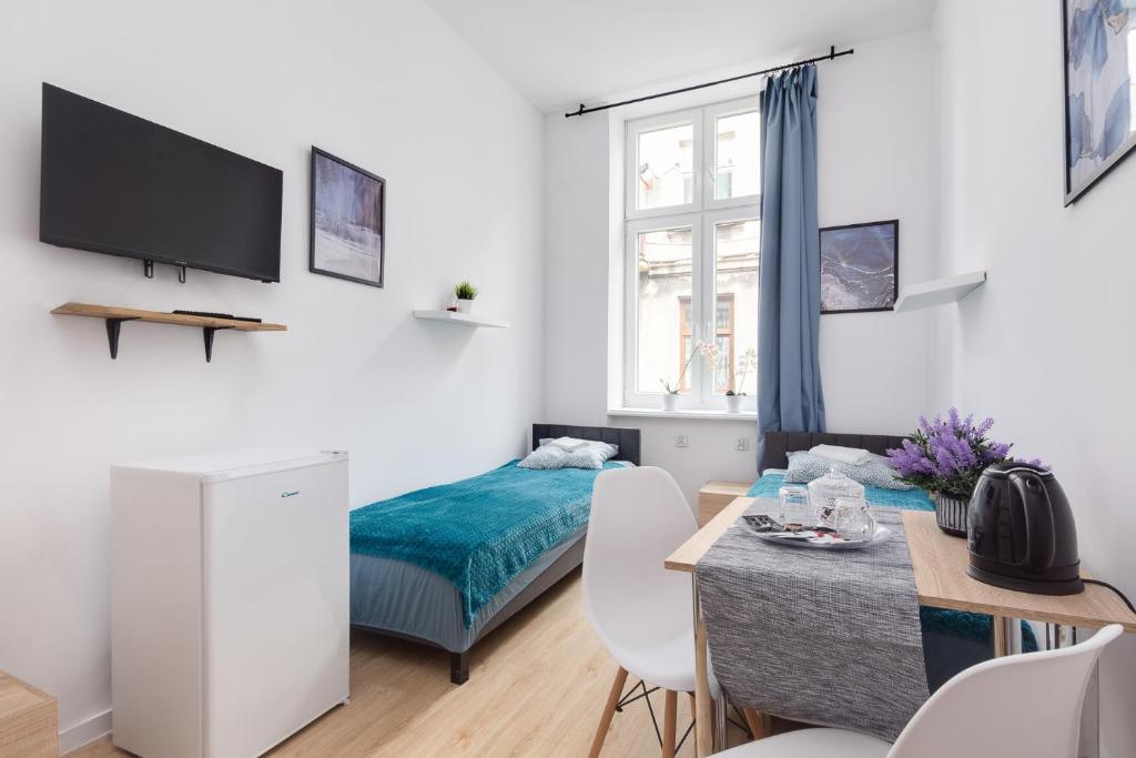 a living room with a bed and a dining room at Centrum2a Łódź Próchnika 21 in Łódź