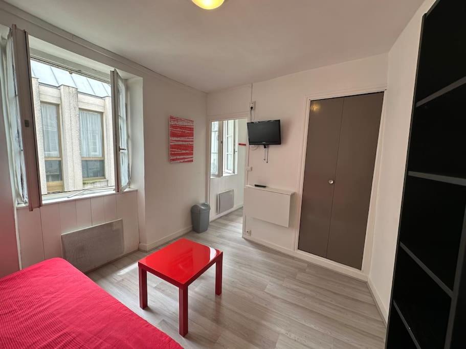 une chambre avec un lit rouge et un tabouret rouge dans l'établissement Charmant studio Carmes 4 - CDDT, à La Rochelle