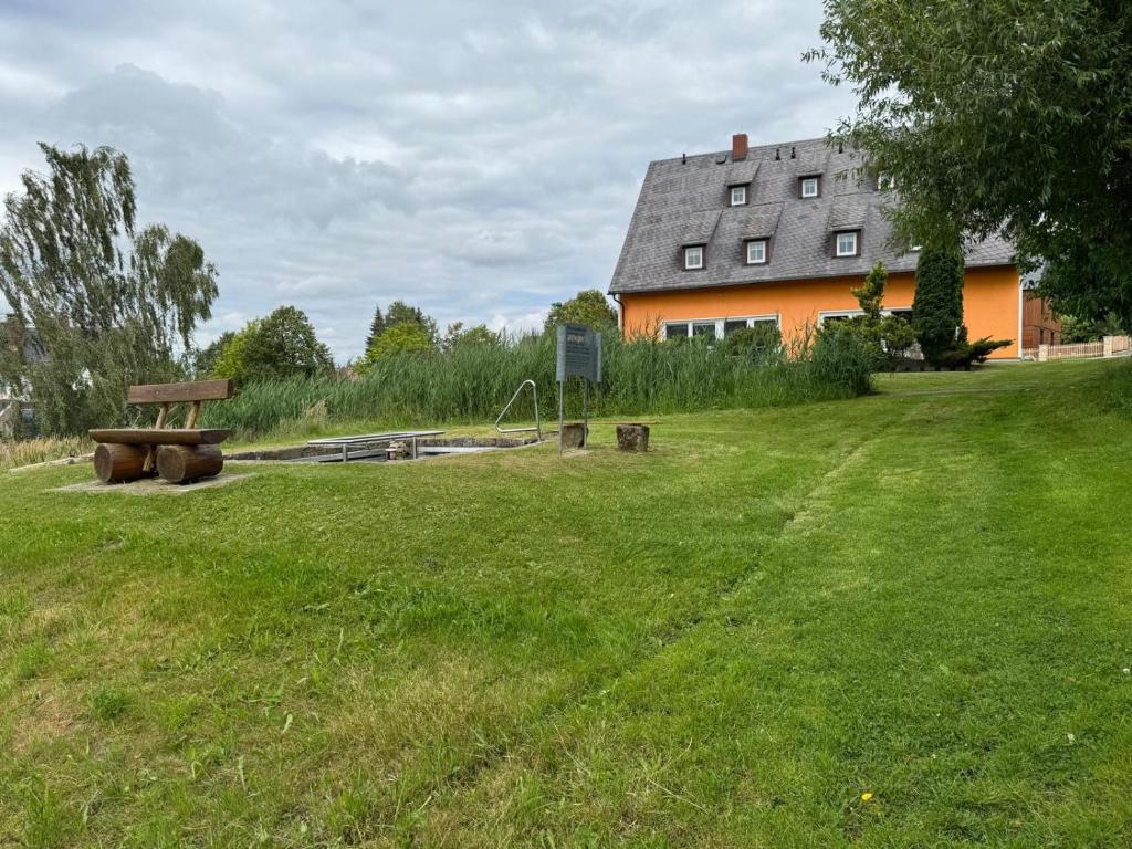 a yard with a bench and a building at Ferienwohnung Auf der Heide in Großschönau