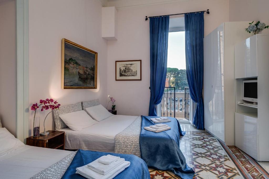 a room with two beds and a window with blue curtains at Otium Maecenatis Apartments in Rome