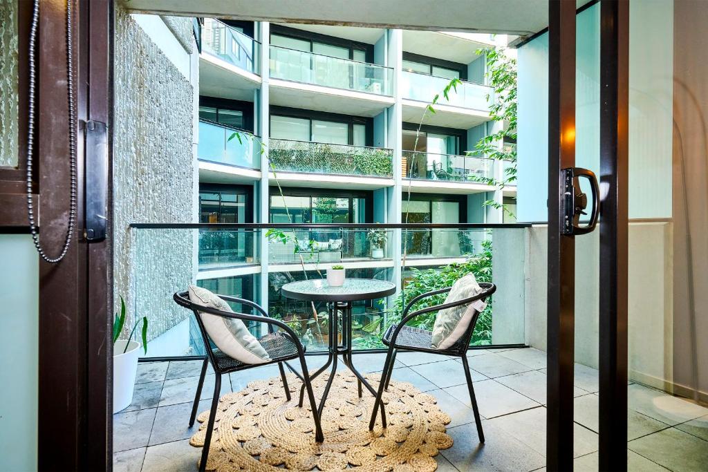 un balcon avec une table et des chaises devant un immeuble dans l'établissement Stylish 1 Bedroom Retreat in St Kilda w Car Park, à Melbourne