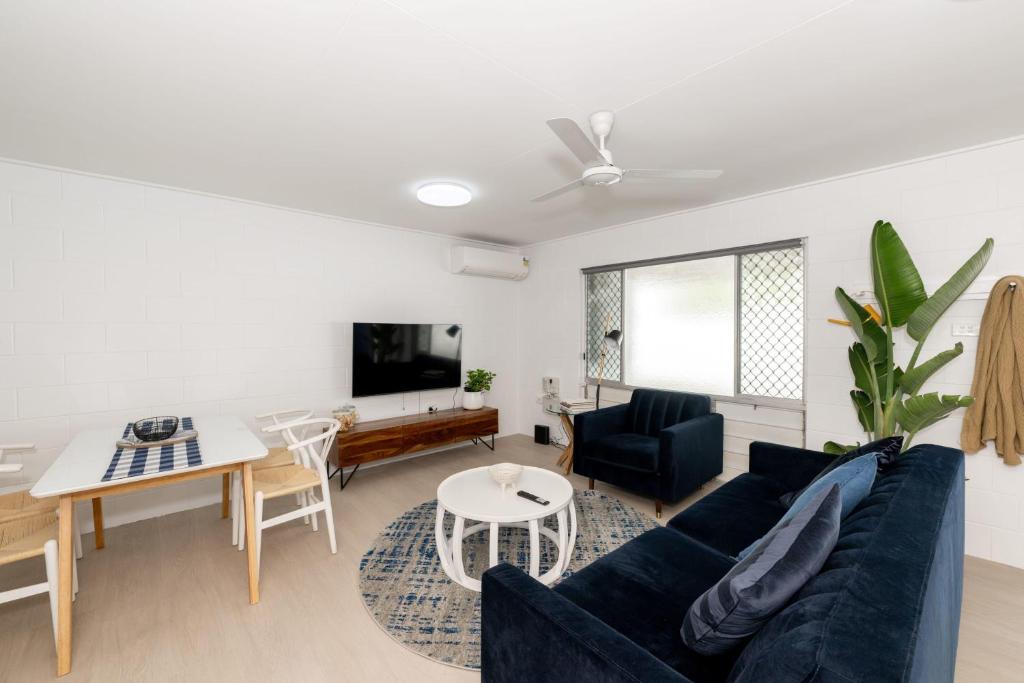 a living room with a blue couch and a table at 2-Bedroom Charm near Mater Hospital Pimlico in Aitkenvale