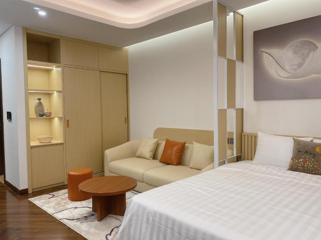 a hotel room with a bed and a couch at Cozy studio Apartment in Diamond Crown Hai Phong 1218A in Hai Phong
