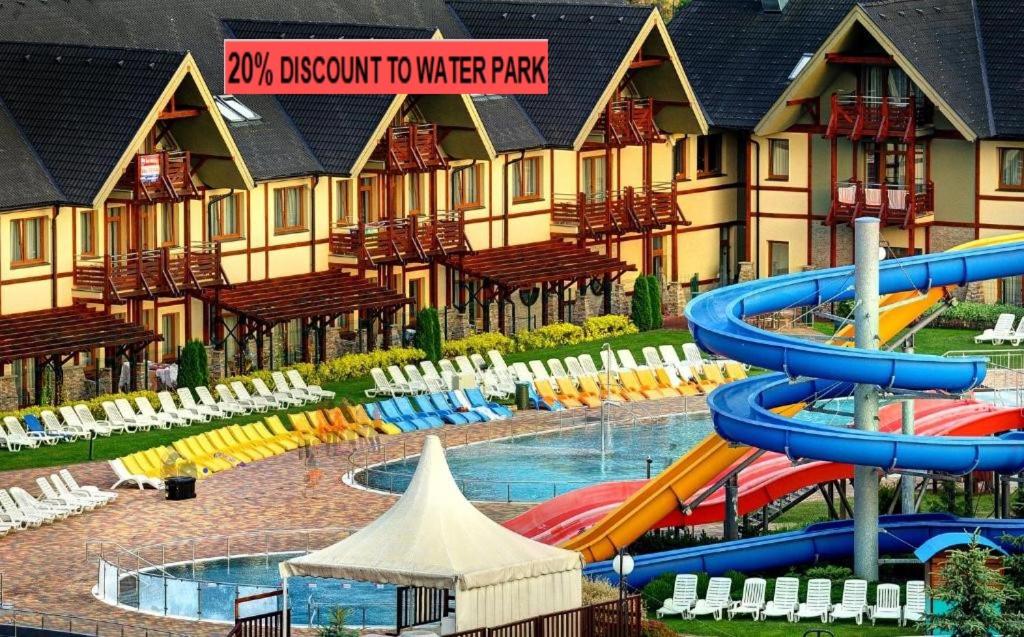 a water park with a water slide in front of a building at Apartmán Liptov - Hotel Bešeňová in Bešeňová