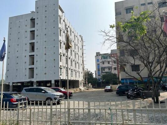 a parking lot with cars parked in front of buildings at DLR GRAND in Tirupati