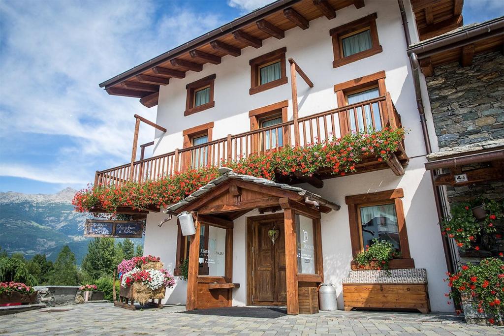 un edificio con balcón y flores. en Relais du Berger, en Aosta