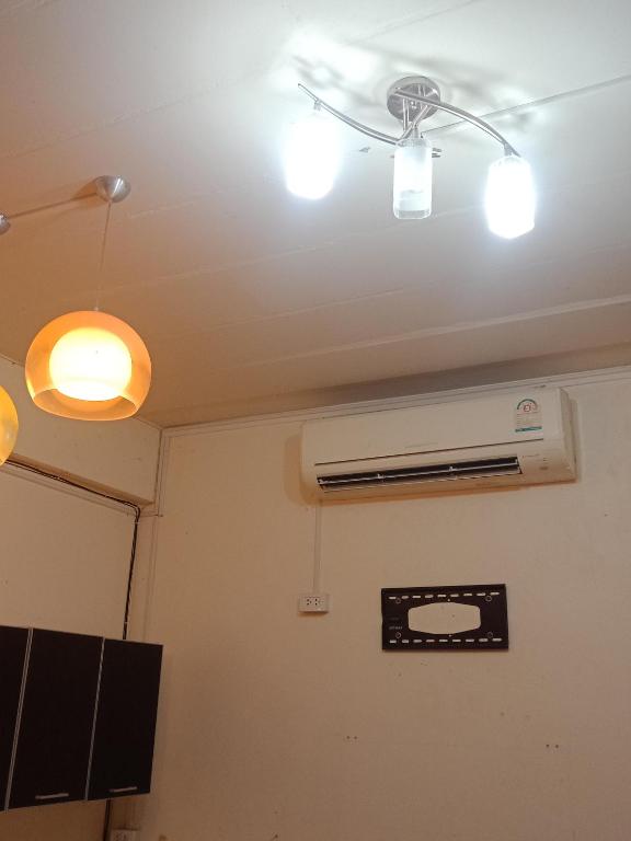 a room with three lights on the ceiling at มังกรเลโฮสเทล Mangkonlay Hostel in Ban Khlong Pak