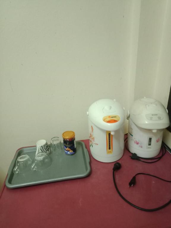 two machines sitting on a table with a tray at มังกรเลโฮสเทล Mangkonlay Hostel in Ban Khlong Pak