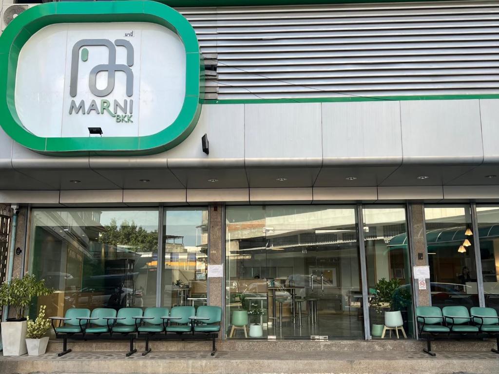 Un escaparate de un centro comercial con sillas verdes. en Marni BKK Hostel, en Bangkok