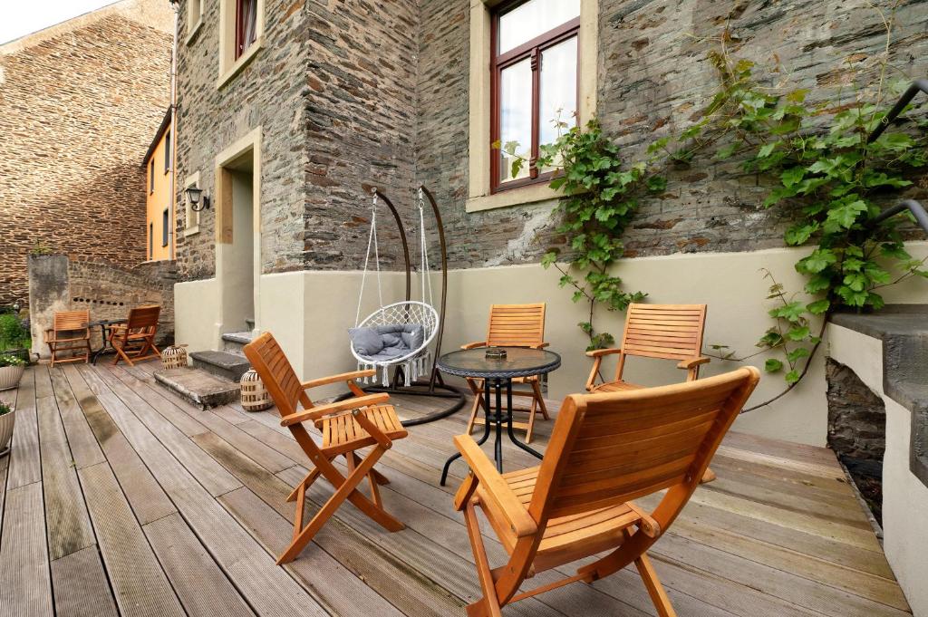 een patio met stoelen en een tafel en een gebouw bij Alte Stadtvilla Weinberg 6 in Traben-Trarbach