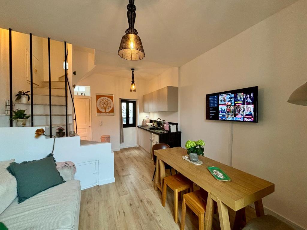 a living room with a couch and a table and a tv at Maison de village a la Turbie in La Turbie