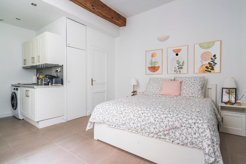 une chambre blanche avec un lit et une cuisine dans l'établissement Apart Merryland Paris Châtelet, à Paris