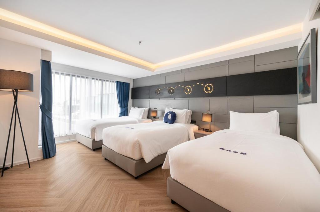Postel nebo postele na pokoji v ubytování Kokotel Chiang Rai Airport Suites