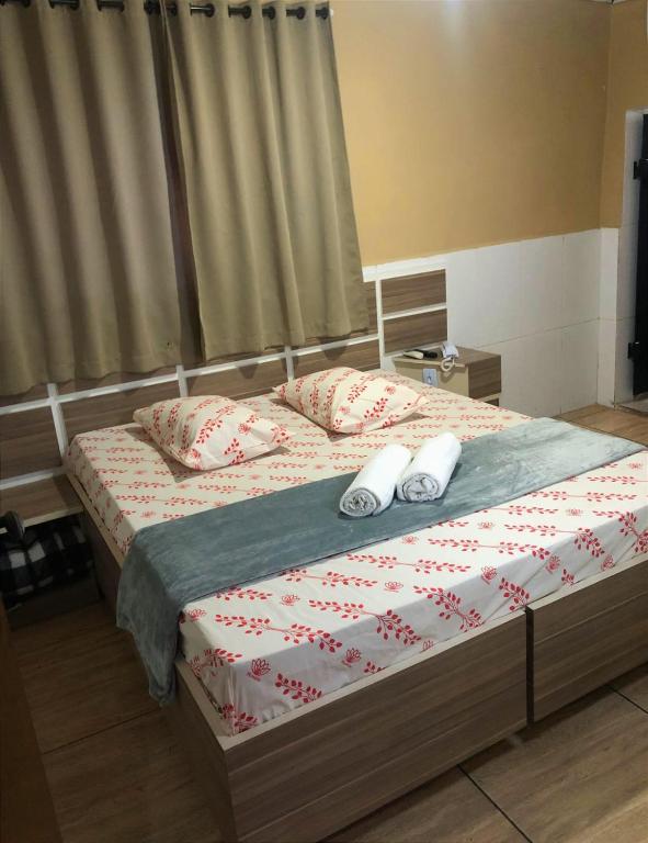 a bedroom with a bed with two slippers on it at Hotel itaquera Inn in Sao Paulo